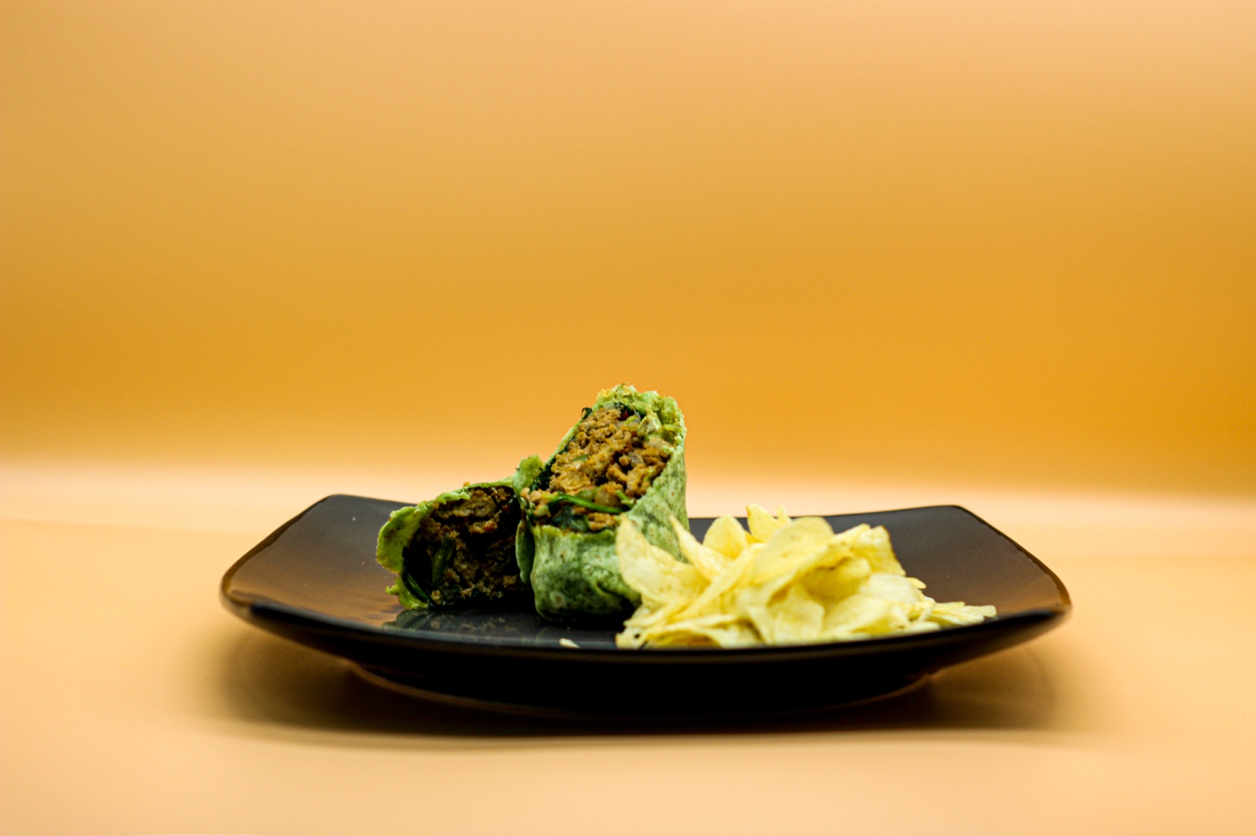 Spinach wrap with lentil filling and chips