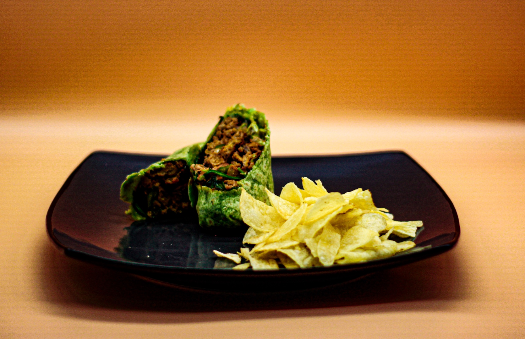 Spinach wrap with seasoned filling and crispy chips