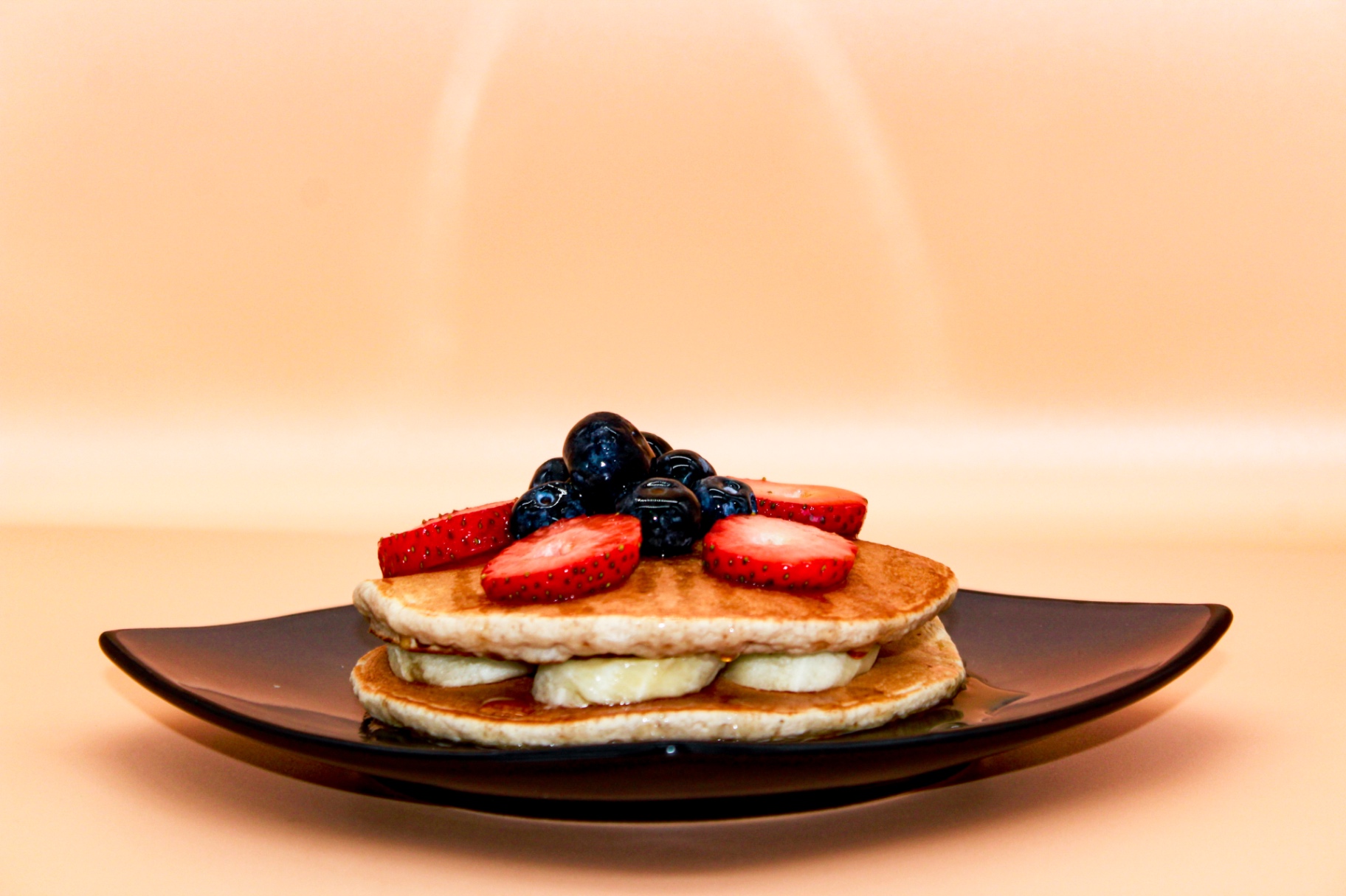 Protein pancakes stacked with berries and banana