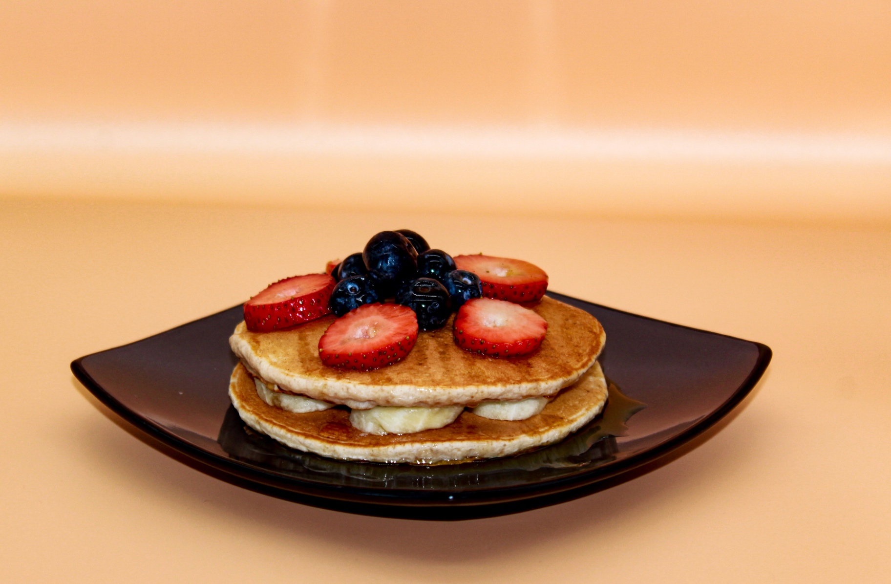 Berry pancake stack with maple syrup
